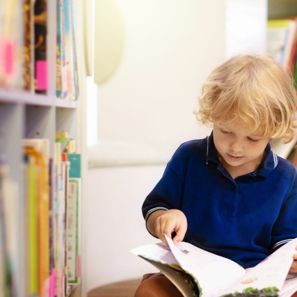 student reading book in classroom library